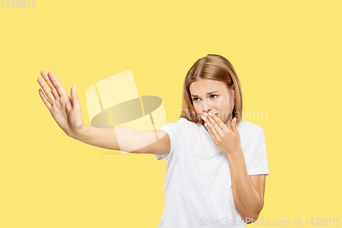 Image of Caucasian young woman\'s half-length portrait on yellow background