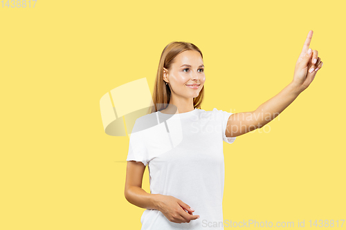 Image of Caucasian young woman\'s half-length portrait on yellow background