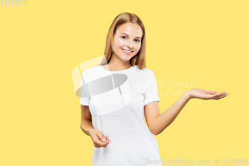 Image of Caucasian young woman\'s half-length portrait on yellow background