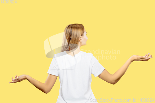 Image of Caucasian young woman\'s half-length portrait on yellow background