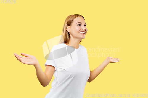 Image of Caucasian young woman\'s half-length portrait on yellow background