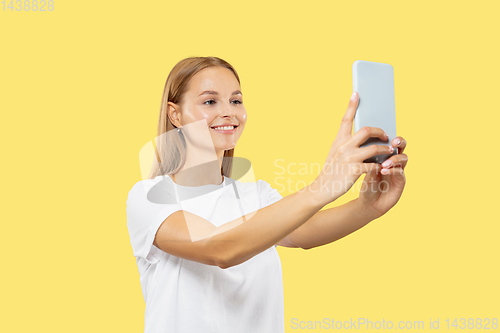 Image of Caucasian young woman\'s half-length portrait on yellow background