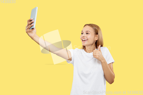 Image of Caucasian young woman\'s half-length portrait on yellow background