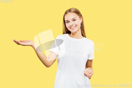 Image of Caucasian young woman\'s half-length portrait on yellow background