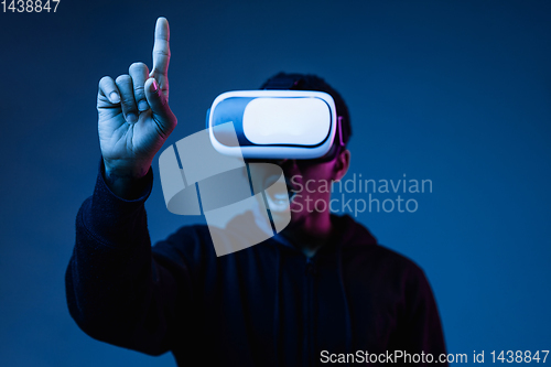 Image of Young african-american man\'s using VR-glasses in neon light