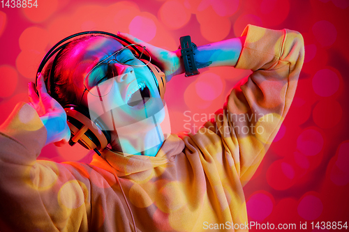 Image of Young woman singing on multi-colored bokeh background