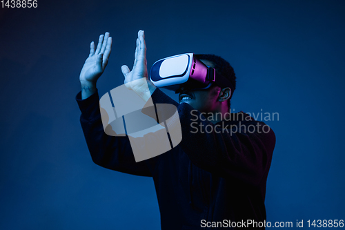 Image of Young african-american man\'s using VR-glasses in neon light