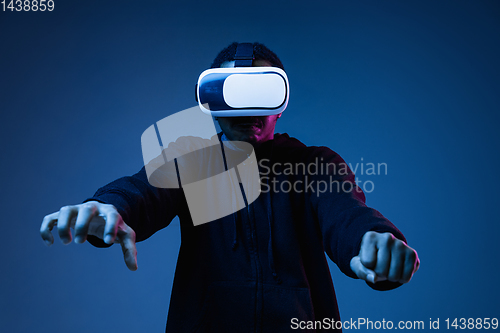 Image of Young african-american man\'s using VR-glasses in neon light