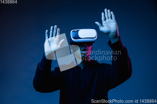 Image of Young african-american man\'s using VR-glasses in neon light