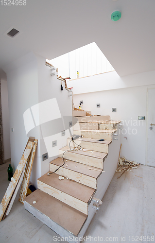 Image of work in progress on stylish interior with wooden stairs