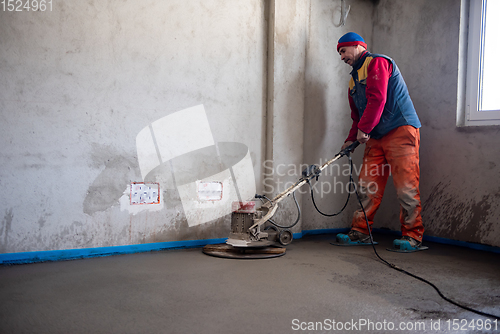 Image of worker performing and polishing sand and cement screed floor