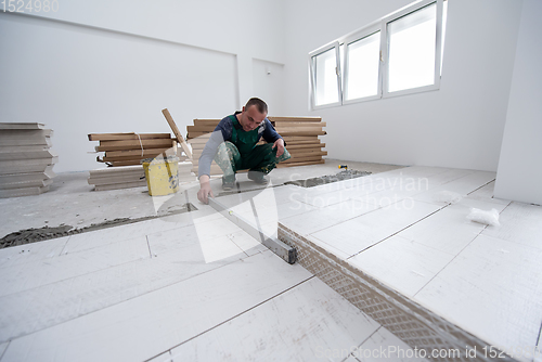 Image of worker installing the ceramic wood effect tiles on the floor