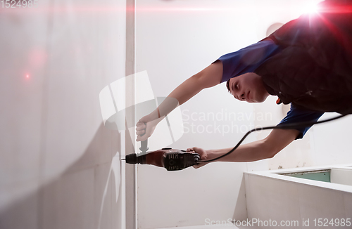 Image of construction worker drilling holes in the bathroom