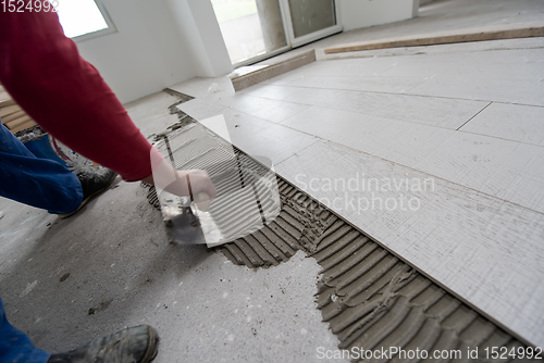 Image of worker installing the ceramic wood effect tiles on the floor