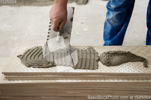 Image of worker installing the ceramic wood effect tiles on the floor