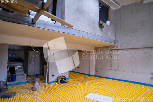 Image of yellow underfloor heating installation with white pipes