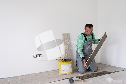 Image of worker installing the ceramic wood effect tiles on the floor