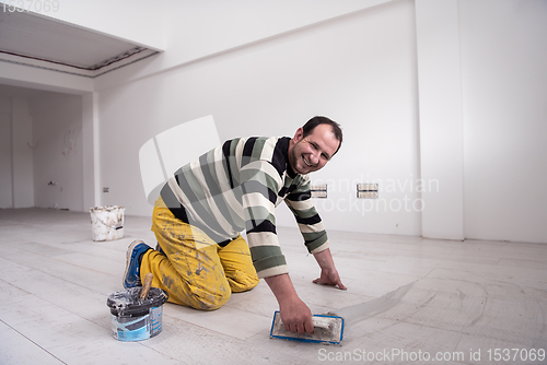 Image of Tilers filling the space between ceramic wood effect tiles