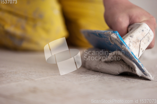 Image of Tilers filling the space between ceramic wood effect tiles