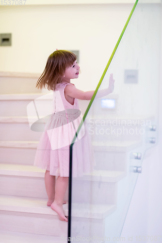 Image of little girl playing on stairs at home