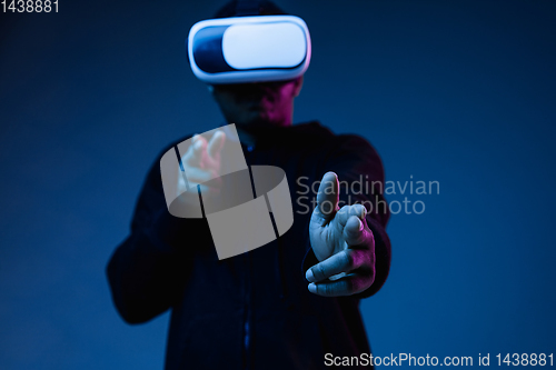 Image of Young african-american man\'s using VR-glasses in neon light