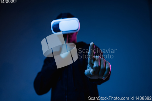 Image of Young african-american man\'s using VR-glasses in neon light