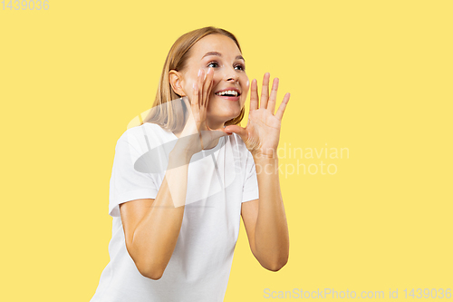 Image of Caucasian young woman\'s half-length portrait on yellow background