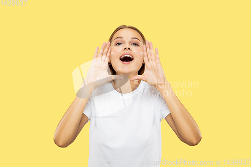 Image of Caucasian young woman\'s half-length portrait on yellow background