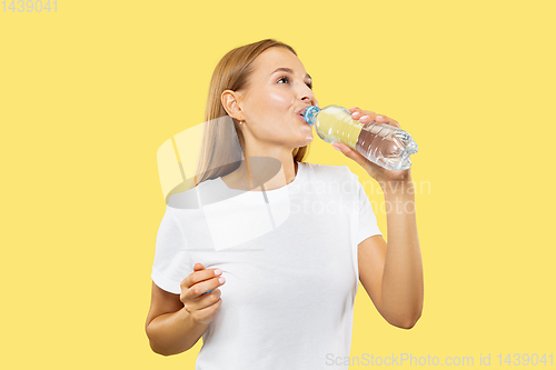Image of Caucasian young woman\'s half-length portrait on yellow background