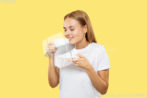 Image of Caucasian young woman\'s half-length portrait on yellow background