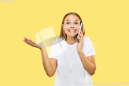 Image of Caucasian young woman\'s half-length portrait on yellow background