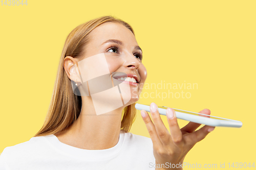 Image of Caucasian young woman\'s half-length portrait on yellow background