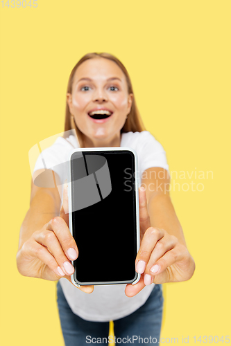 Image of Caucasian young woman\'s half-length portrait on yellow background