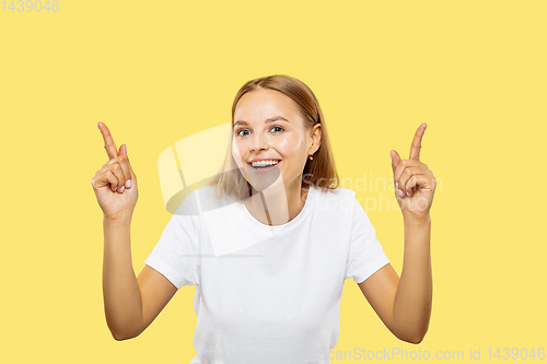 Image of Caucasian young woman\'s half-length portrait on yellow background