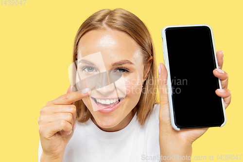 Image of Caucasian young woman\'s half-length portrait on yellow background
