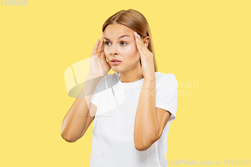 Image of Caucasian young woman\'s half-length portrait on yellow background