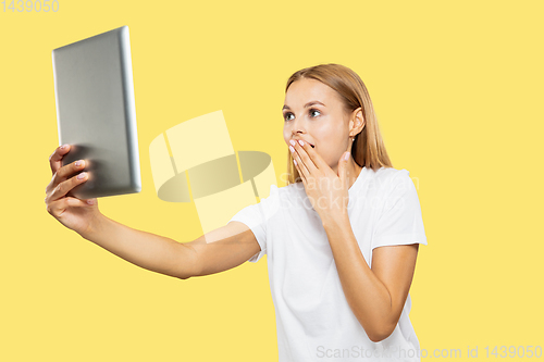 Image of Caucasian young woman\'s half-length portrait on yellow background