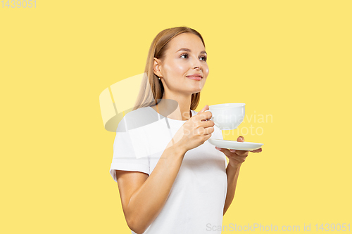 Image of Caucasian young woman\'s half-length portrait on yellow background