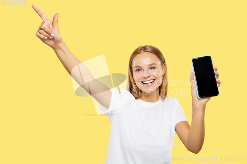 Image of Caucasian young woman\'s half-length portrait on yellow background