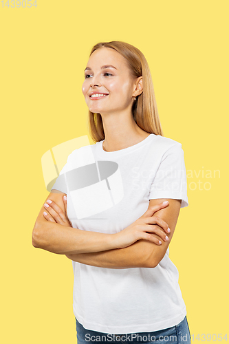 Image of Caucasian young woman\'s half-length portrait on yellow background