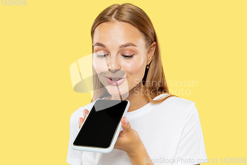 Image of Caucasian young woman\'s half-length portrait on yellow background