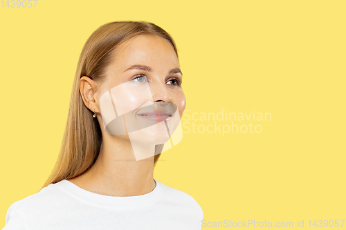 Image of Caucasian young woman\'s half-length portrait on yellow background