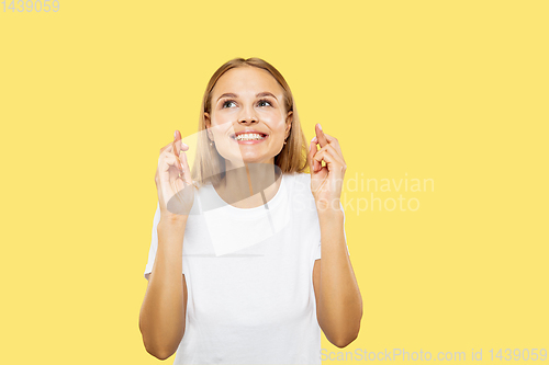 Image of Caucasian young woman\'s half-length portrait on yellow background