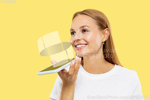 Image of Caucasian young woman\'s half-length portrait on yellow background