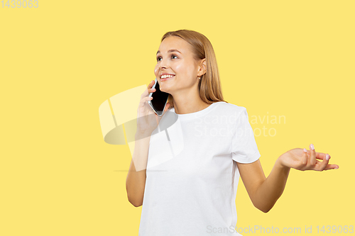 Image of Caucasian young woman\'s half-length portrait on yellow background
