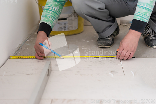 Image of worker installing the ceramic wood effect tiles on the floor