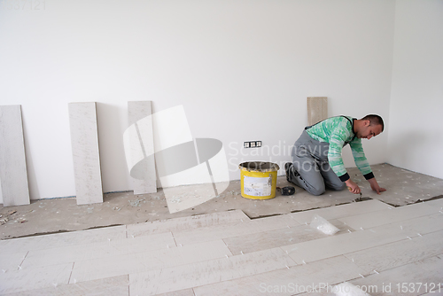 Image of worker installing the ceramic wood effect tiles on the floor