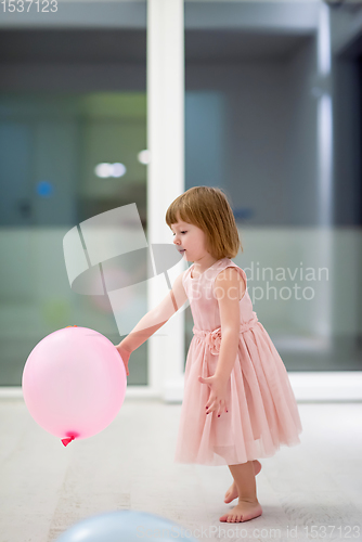 Image of cute little girl playing with balloons