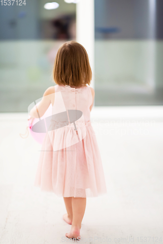 Image of cute little girl playing with balloons