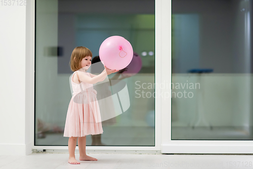 Image of cute little girl playing with balloons